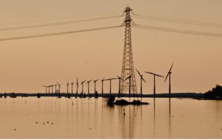 A power line tower in the middle of a body of water
