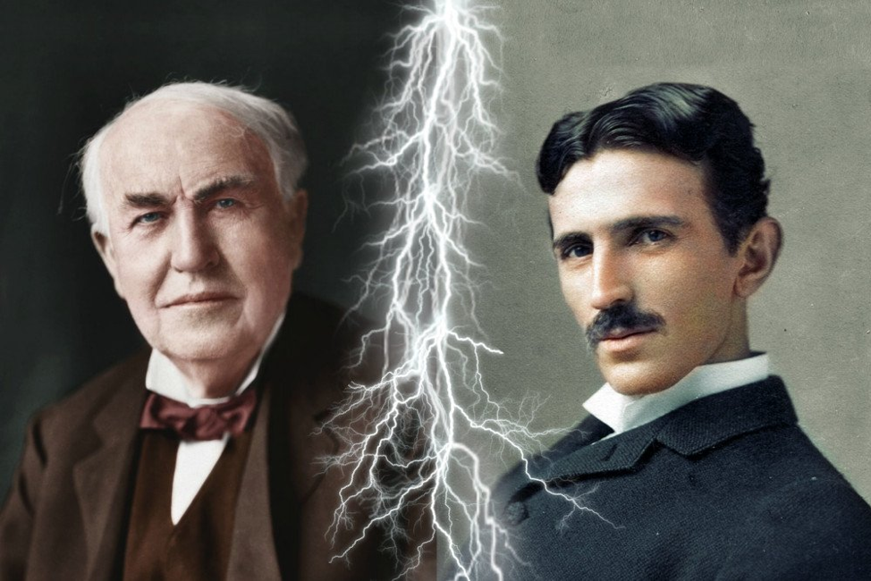 On the left is a photo of Thomas Edison, with gray hair and a brown suit. On the right is a photo of Tesla, with black hair, a moustache, and a black suit. In between the two photos is a bolt of lightning.