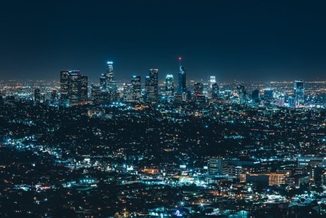 A stunning, panoramic view of Chicago, IL at night with buildings and skyscrapers lighting the dark sky.