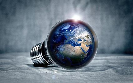 An edited image of the Earth encapsulated within a lightbulb, reflecting the connection between the Earth and energy savings.