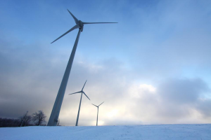An image of a wind turbine jutting out of a snowy landscape.